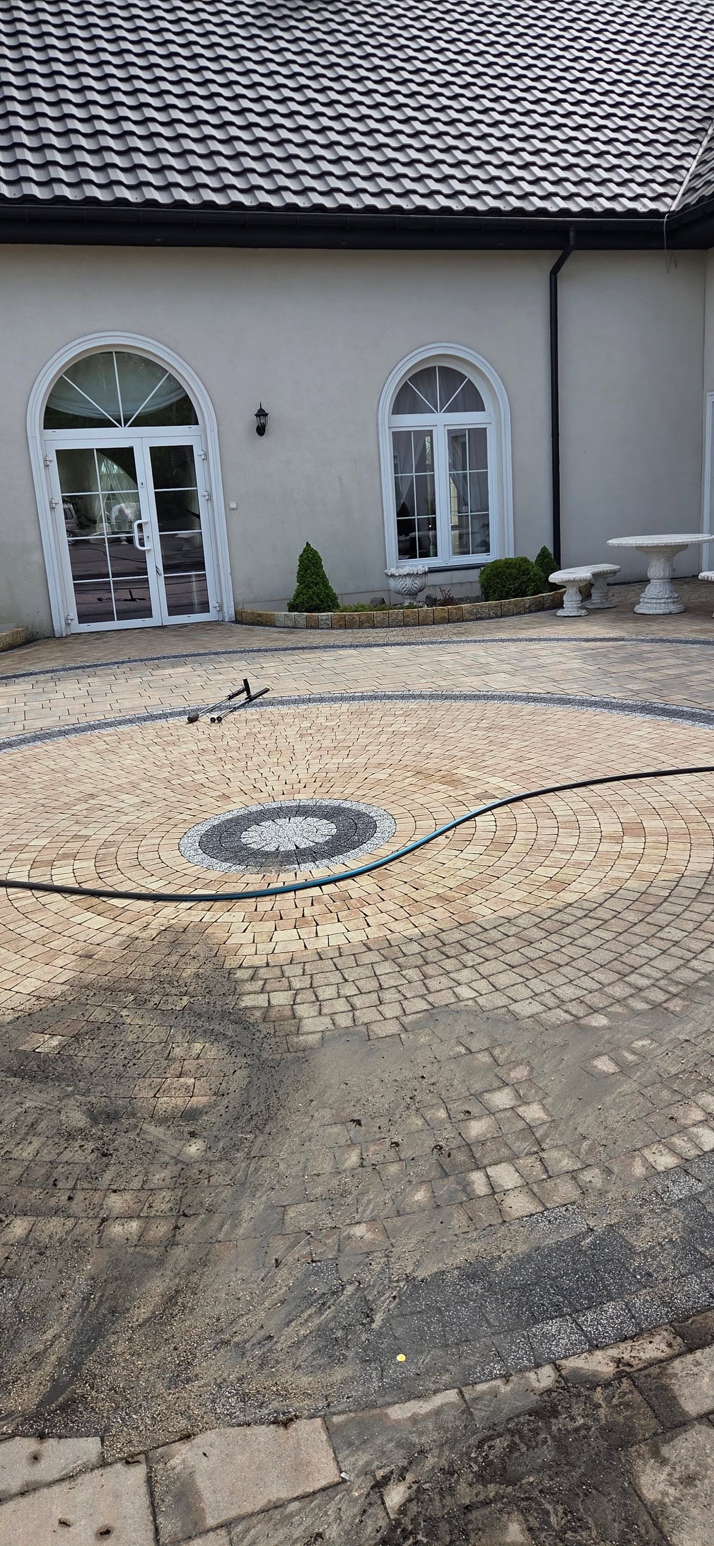 Plac z kostki brukowej z rozetą przed rezydencją w trakcie czyszczenia
